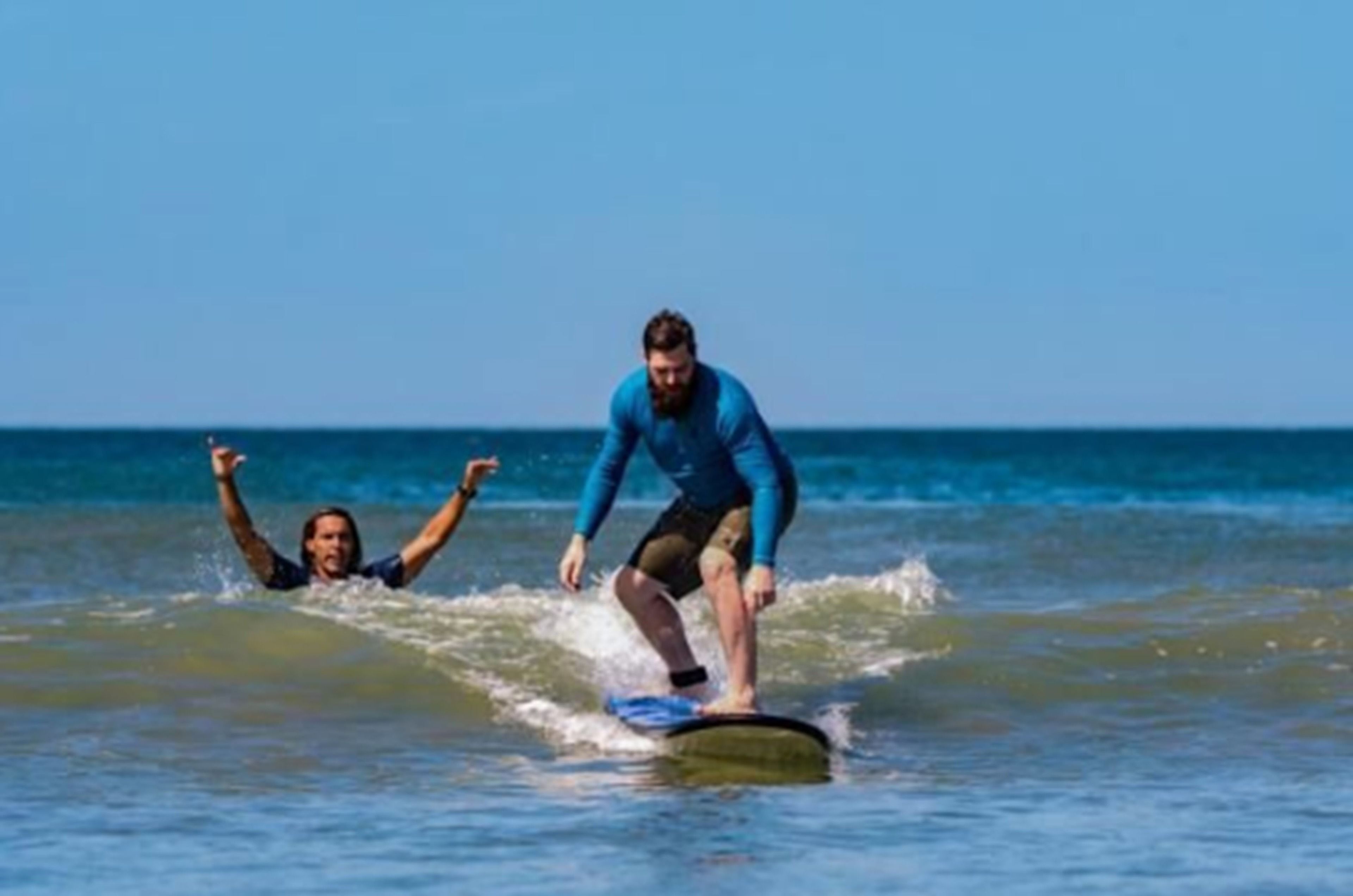 Two people surfing on a wave in the ocean.