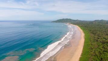 En la playa, playa de arena blanca, toallas de playa y surf