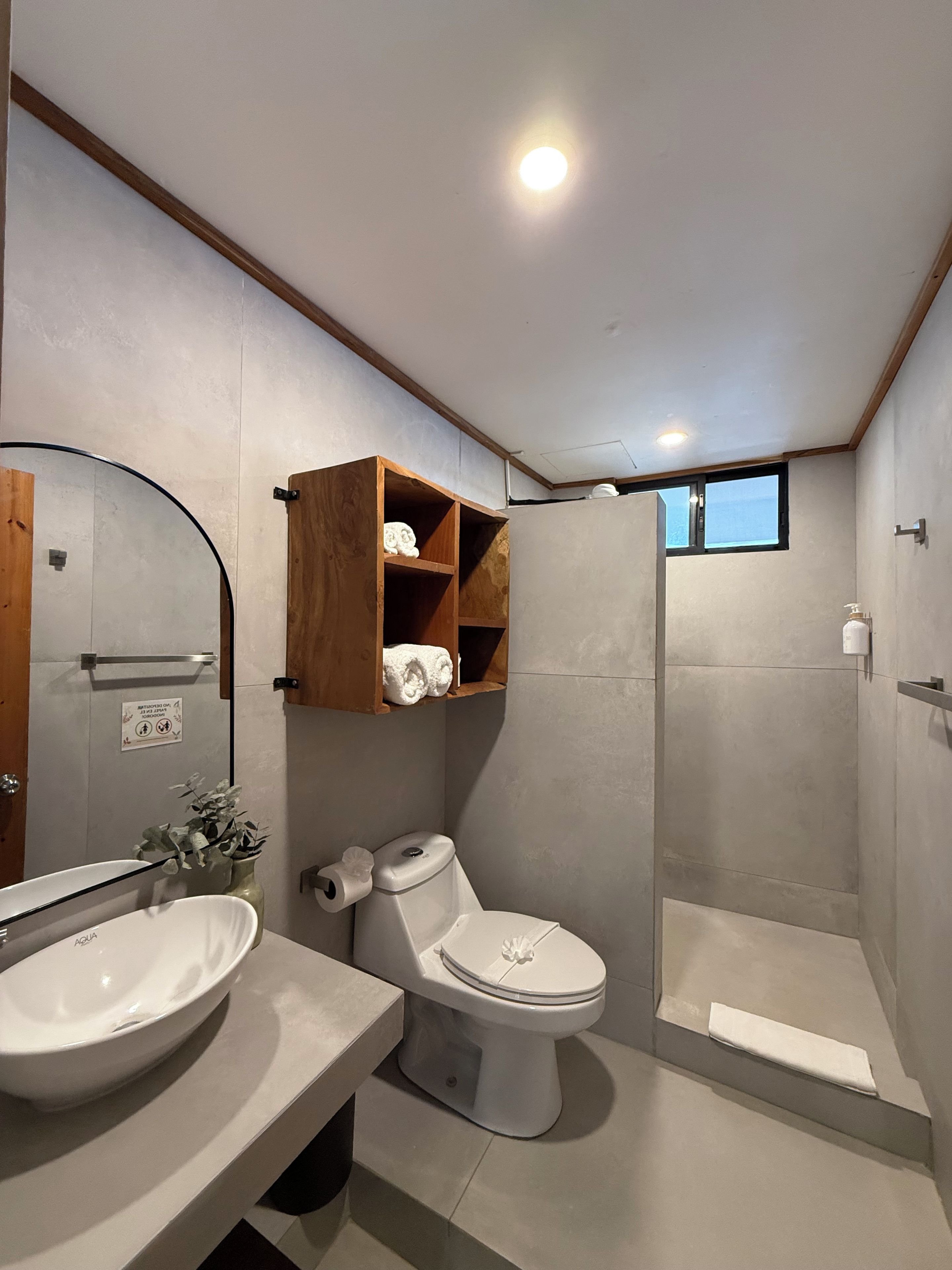 Een moderne badkamer met toilet, wastafel en douche.