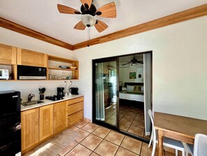 A compact kitchen with wooden cabinets, a microwave, and a coffee maker.