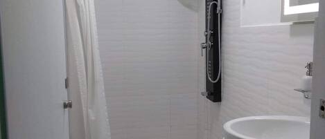 A modern bathroom with a shower, toilet, and sink.