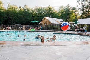 Una piscina al aire libre, sillones reclinables de piscina