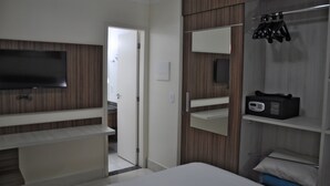 A modern hotel room with a flat-screen TV, a built-in vanity with a mirror, and a shoe rack. - Lacqua DiRoma Hotel e Parque- ABD turismo (Caldas Novas)