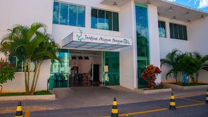 A modern building with a sign reading "Jardins Acqua Parque."