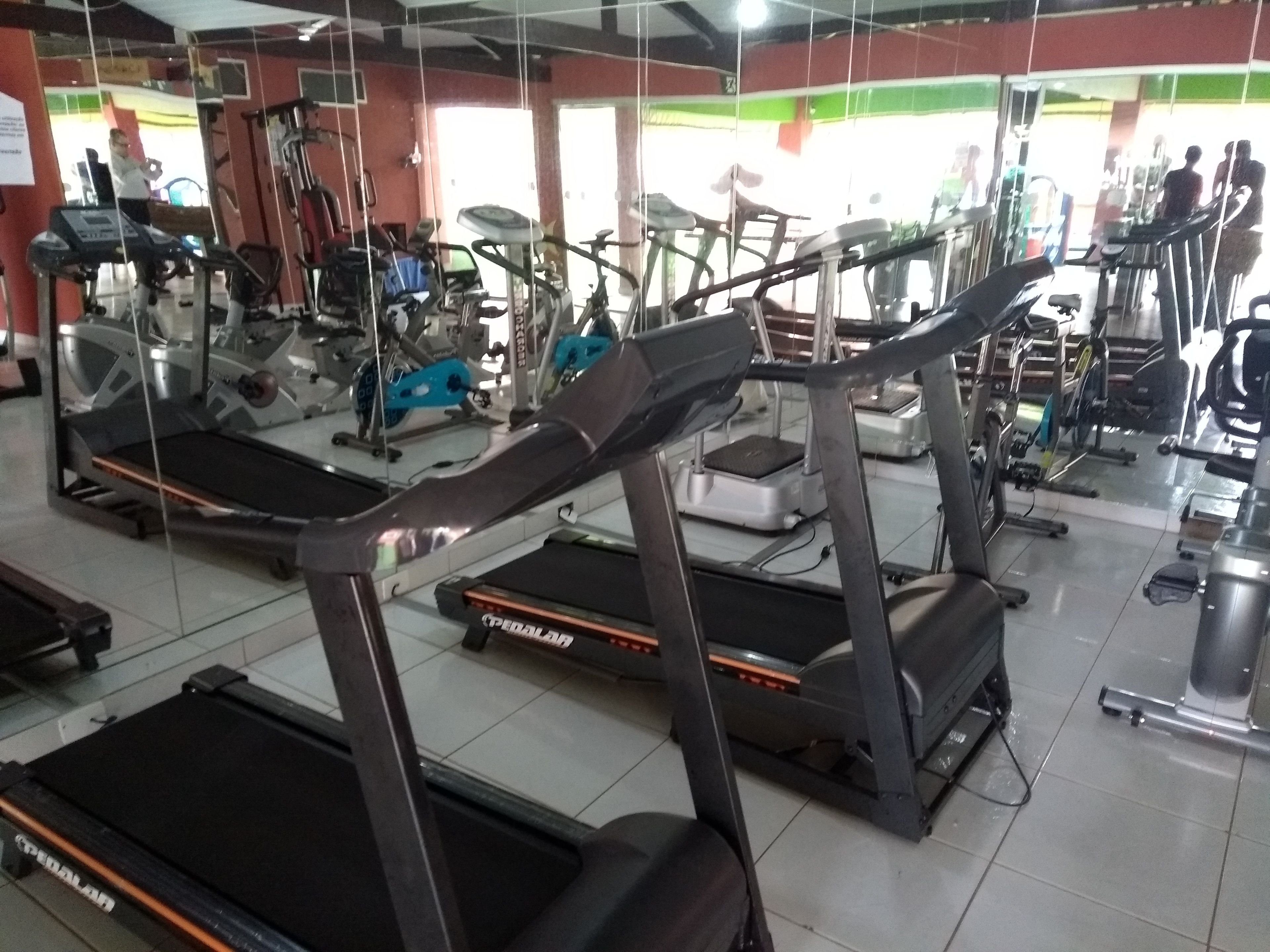 A gym with multiple treadmills, exercise bikes, and weight machines.