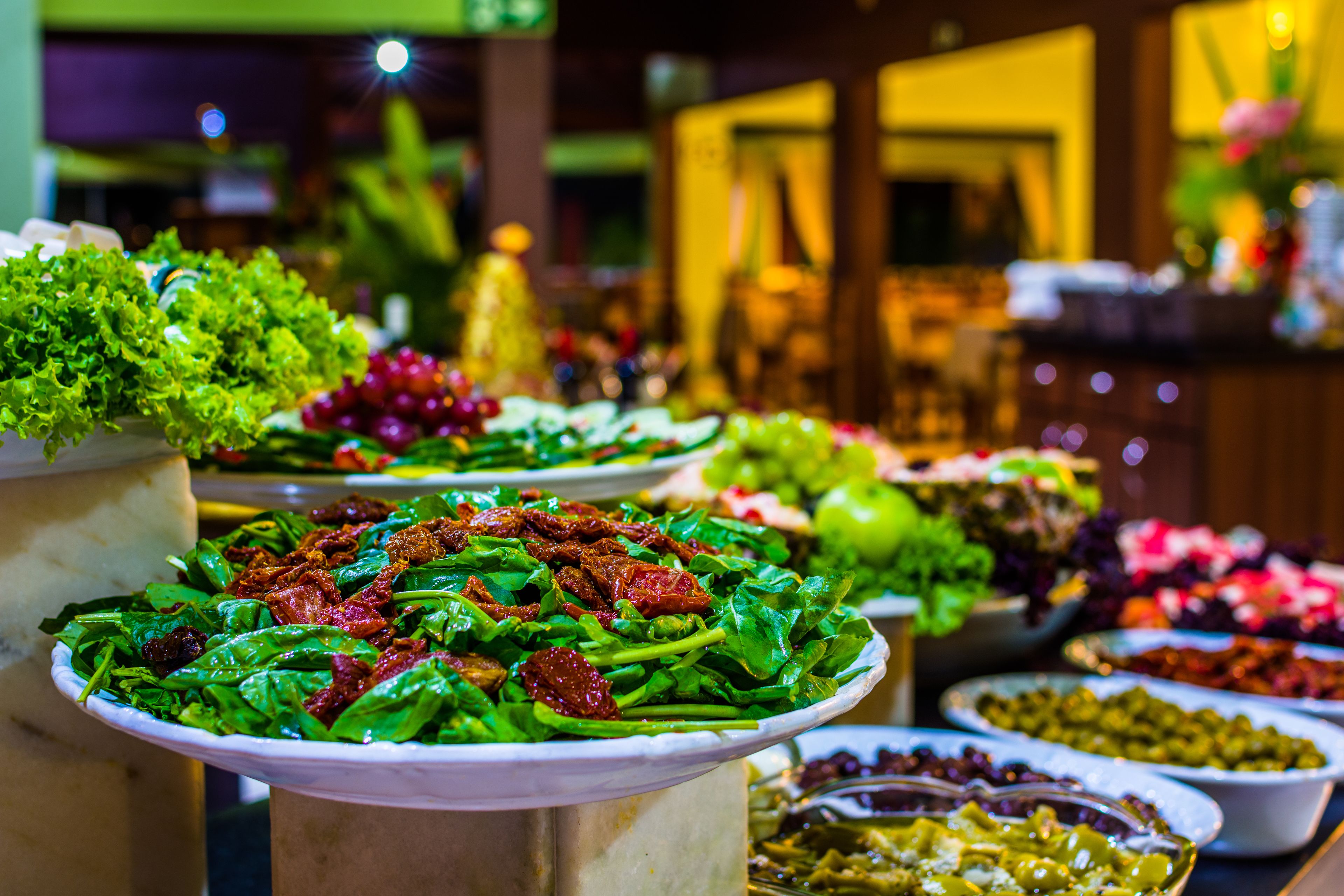 A buffet with various dishes including salads and vegetables.