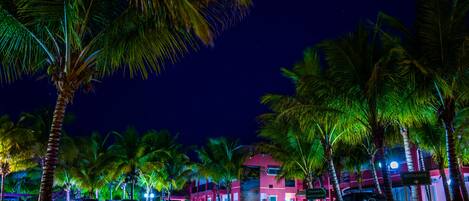 A brightly lit pink building with a sign for a restaurant.