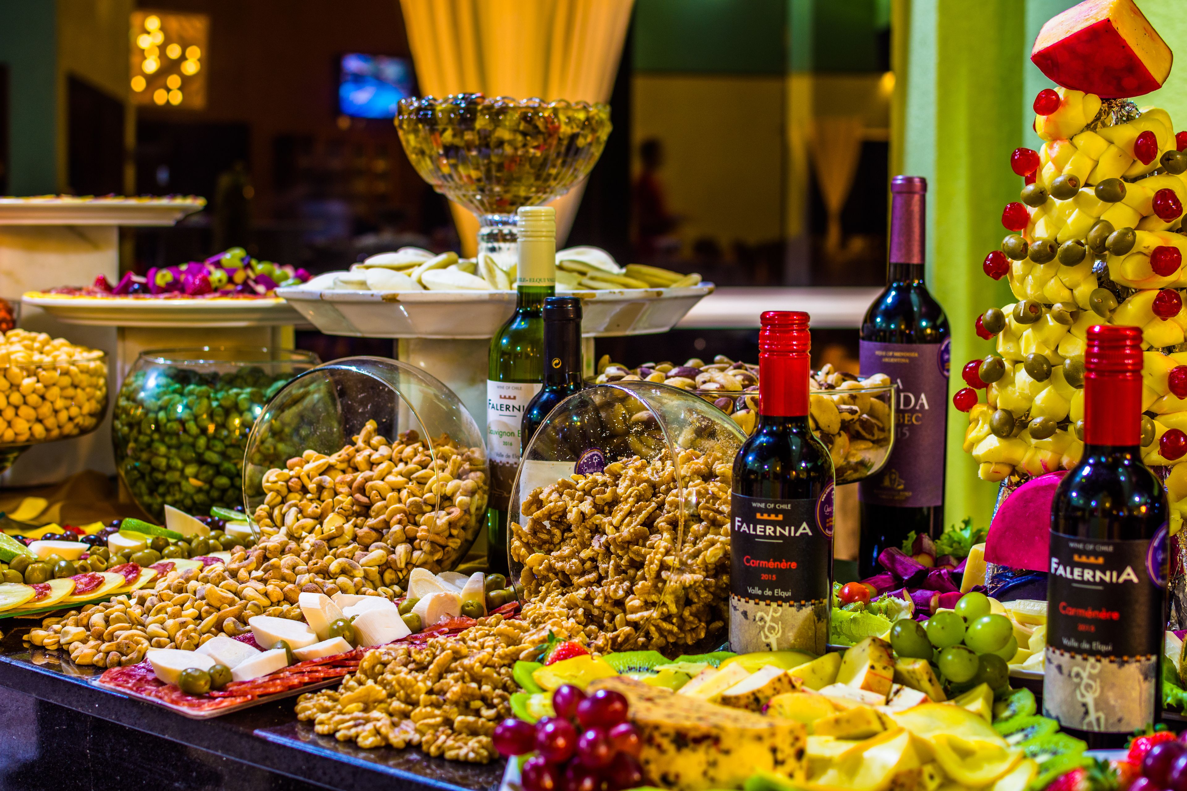 Un bufé con diversas opciones de comida y botellas de vino.