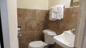 A small bathroom with a toilet, sink, and a towel hanging on the wall.
