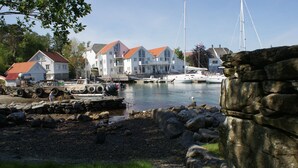 A marina with boats, a dock, and a large white building with red roofs. - Fjordbris Hotell (Stavanger)
