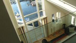 A high-rise apartment with a large window overlooking a marina. - Fjordbris Hotell (Stavanger)