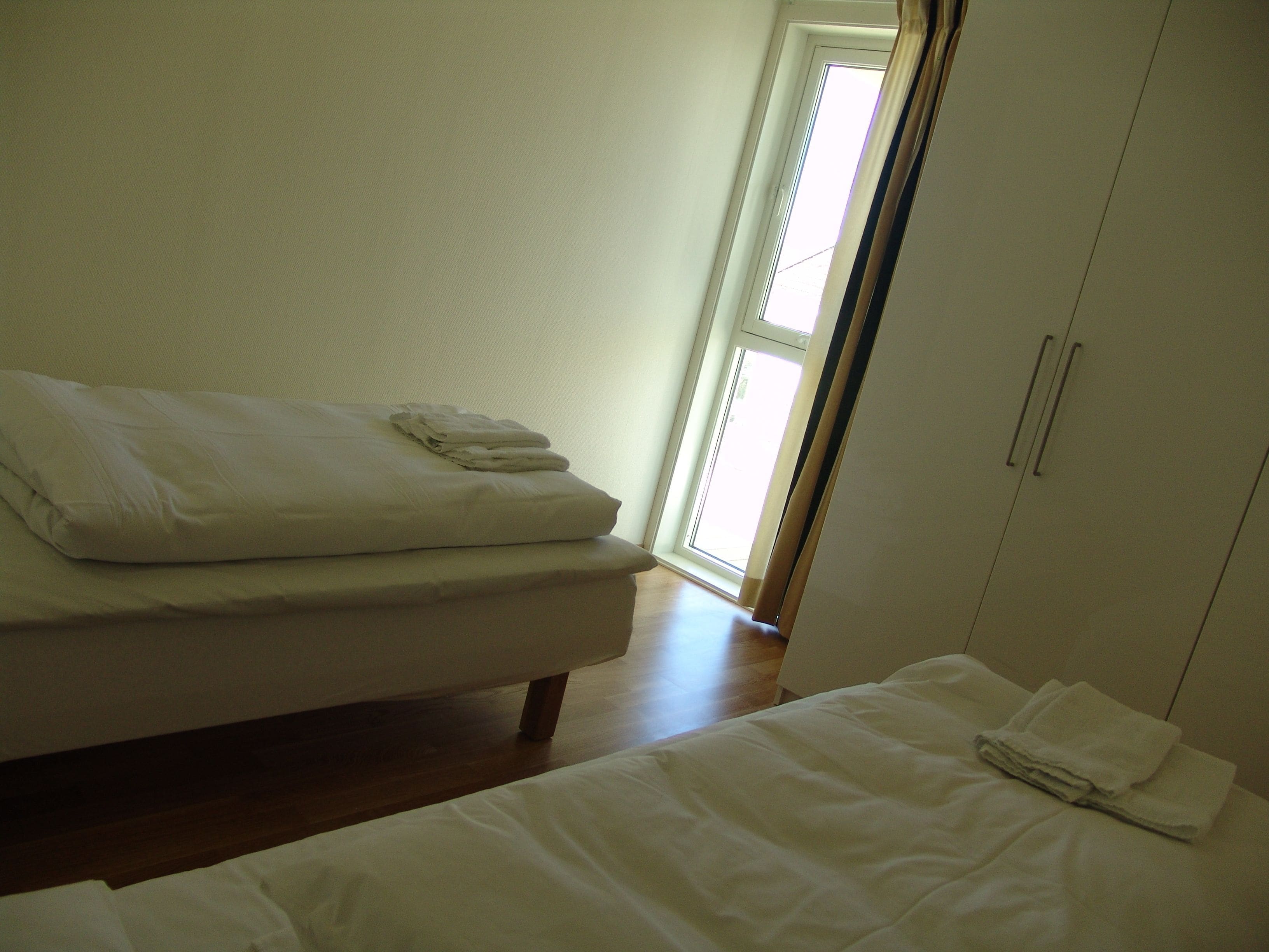 Un dormitorio con cama, mesita de noche y armario.