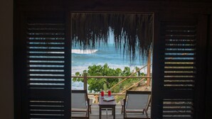 A room with a view of the ocean through open shutters, a wooden table, and two chairs. - Casa Tayrona los Naranjos (Santa Marta)