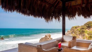A beachside lounge with wicker furniture and a view of the ocean. - Casa Tayrona los Naranjos (Santa Marta)