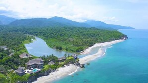 An aerial view of a coastal resort with a beach, clear waters, and lush greenery. - Casa Tayrona los Naranjos (Santa Marta)
