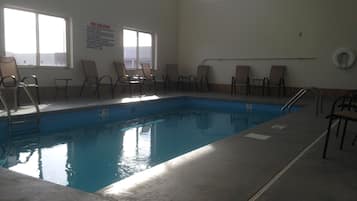 Una piscina cubierta, tumbonas