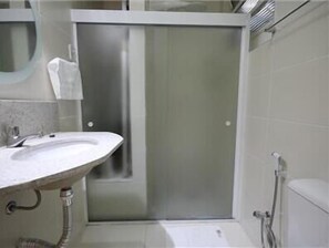 A modern bathroom with a large sink, a toilet, and a shower. - Copacabana 1007 (Rio de Janeiro)
