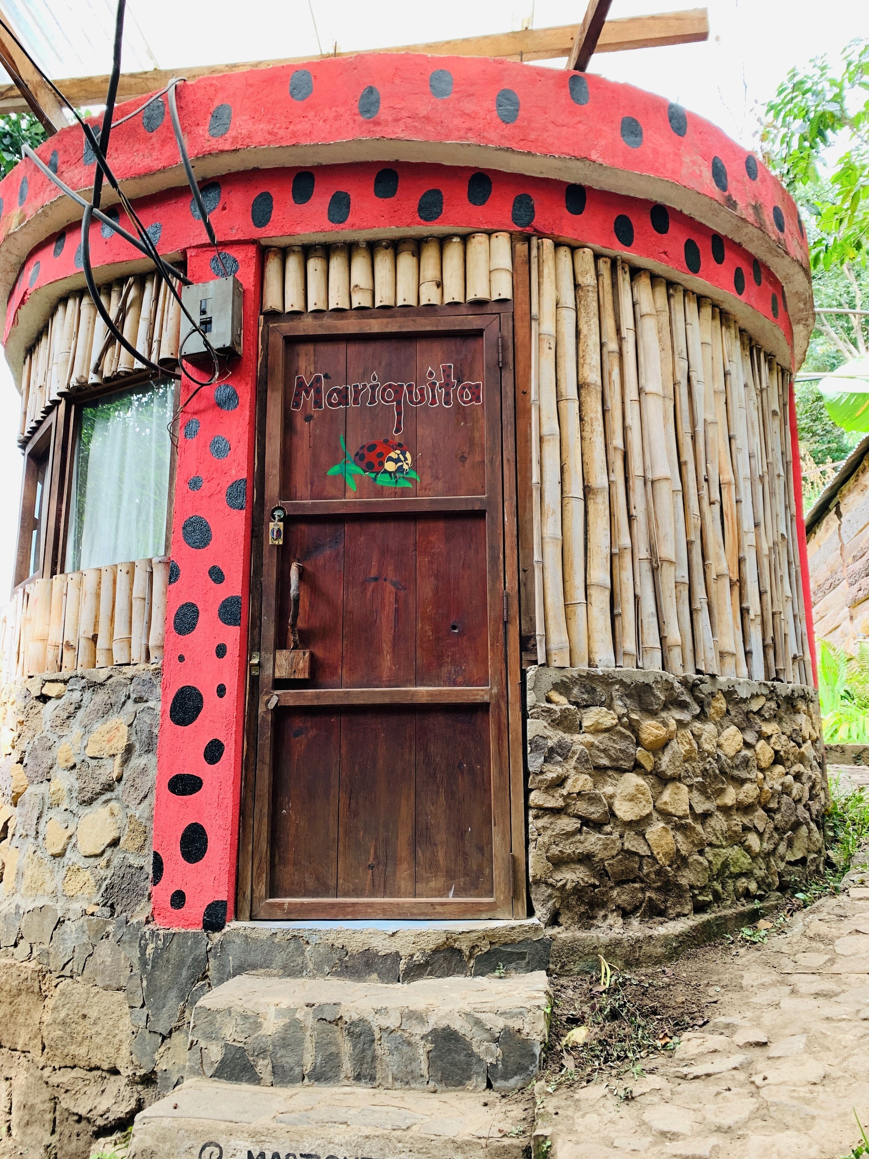 Ein Gebäude mit roter Fassade und einer Holztür mit der Aufschrift 'Marichita'.
