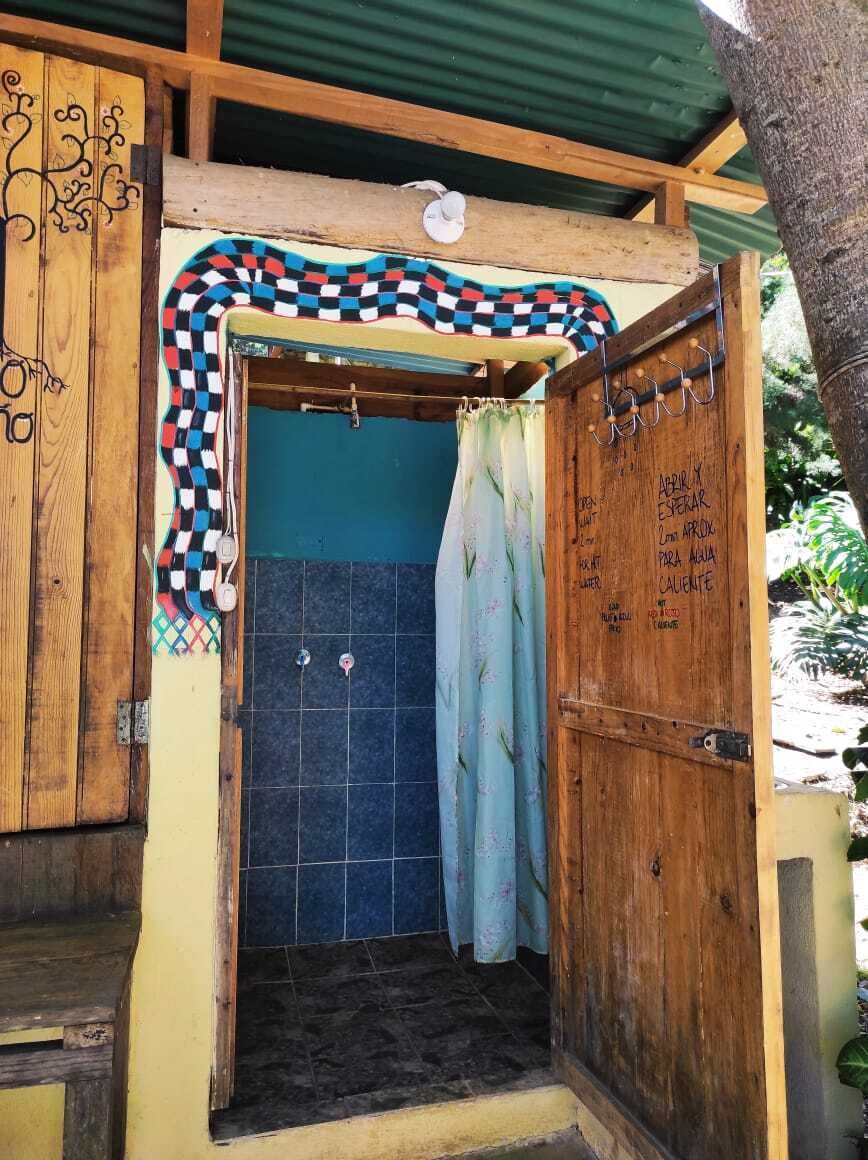 A wooden door with a checkered pattern, a blue tiled wall, and a wooden bench.