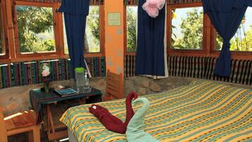 A room with a bed, a table, and a window with curtains.
