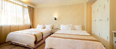 A hotel room with two beds, a wardrobe, and a nightstand.