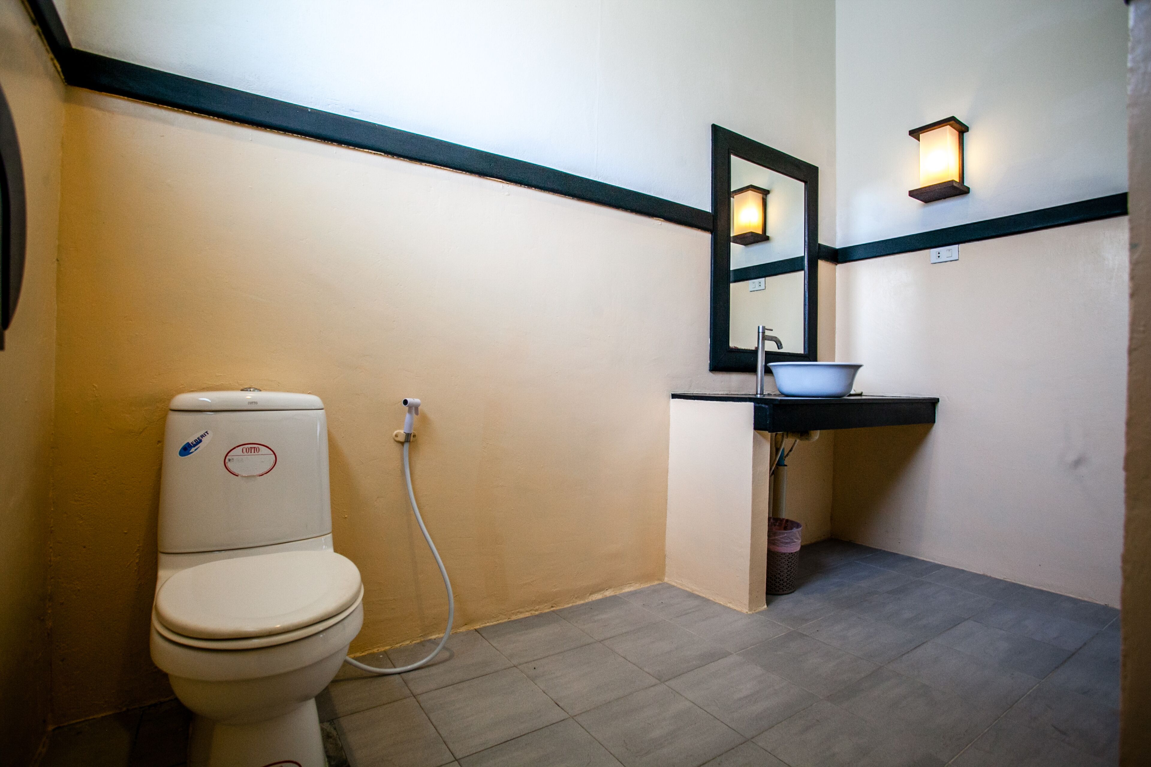 A bathroom with a toilet, sink, and mirror.