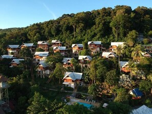 A hillside resort with multiple wooden chalets, a swimming pool, and lush greenery. - Phitharom PP Resort (Ko Phi Phi)