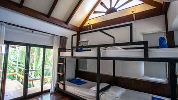 A bunk bed room with a wooden ceiling and a view of greenery outside.