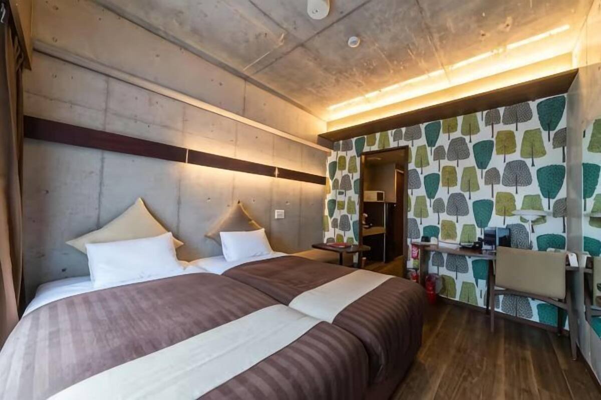 Une chambre d’hôtel avec un grand lit, un bureau et une armoire.