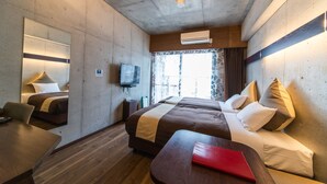 A hotel room with a large bed, a desk, a chair, a TV, and a window with curtains. - Condominio Makishi Annesso (Naha)