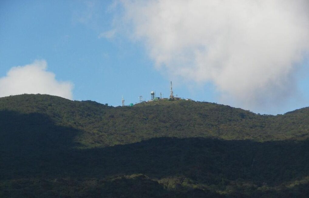 Una colina con varias torres de comunicación en la cima.