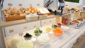 A buffet with various food items including bread, vegetables, and sauces. - Just Inn Premium Nagoya Station (Nagoya)