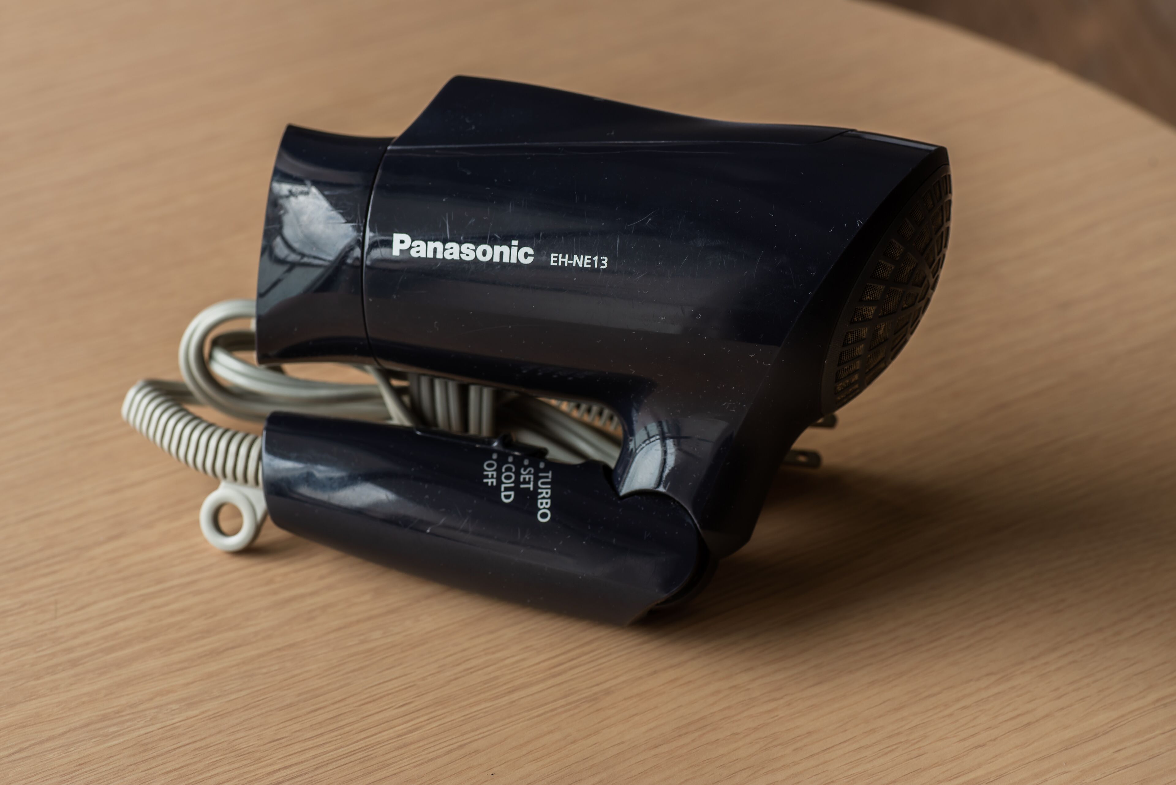 Un vas d'aire Panasonic EH-NE13 sobre una superfície de fusta.