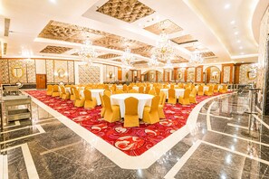 A banquet hall with round tables, yellow chairs, and a red carpet. - Shakun Hotels & Resorts Jaipur (Jaipur)