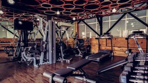 A gym with various exercise equipment, a treadmill, and a bench.