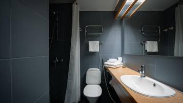 A modern bathroom with a shower, toilet, and sink.