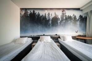 A room with three single beds aligned against a wall, each with white bedding. - Hotelli Uninen Loviisa (Loviisa)