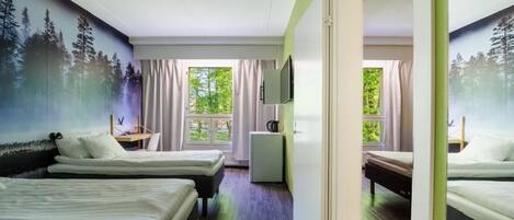 A hotel room with two beds, a desk, a small refrigerator, and a TV.