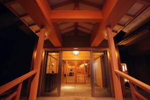Een hotelgevel van hout, glazen deuren en een betegelde vloer.