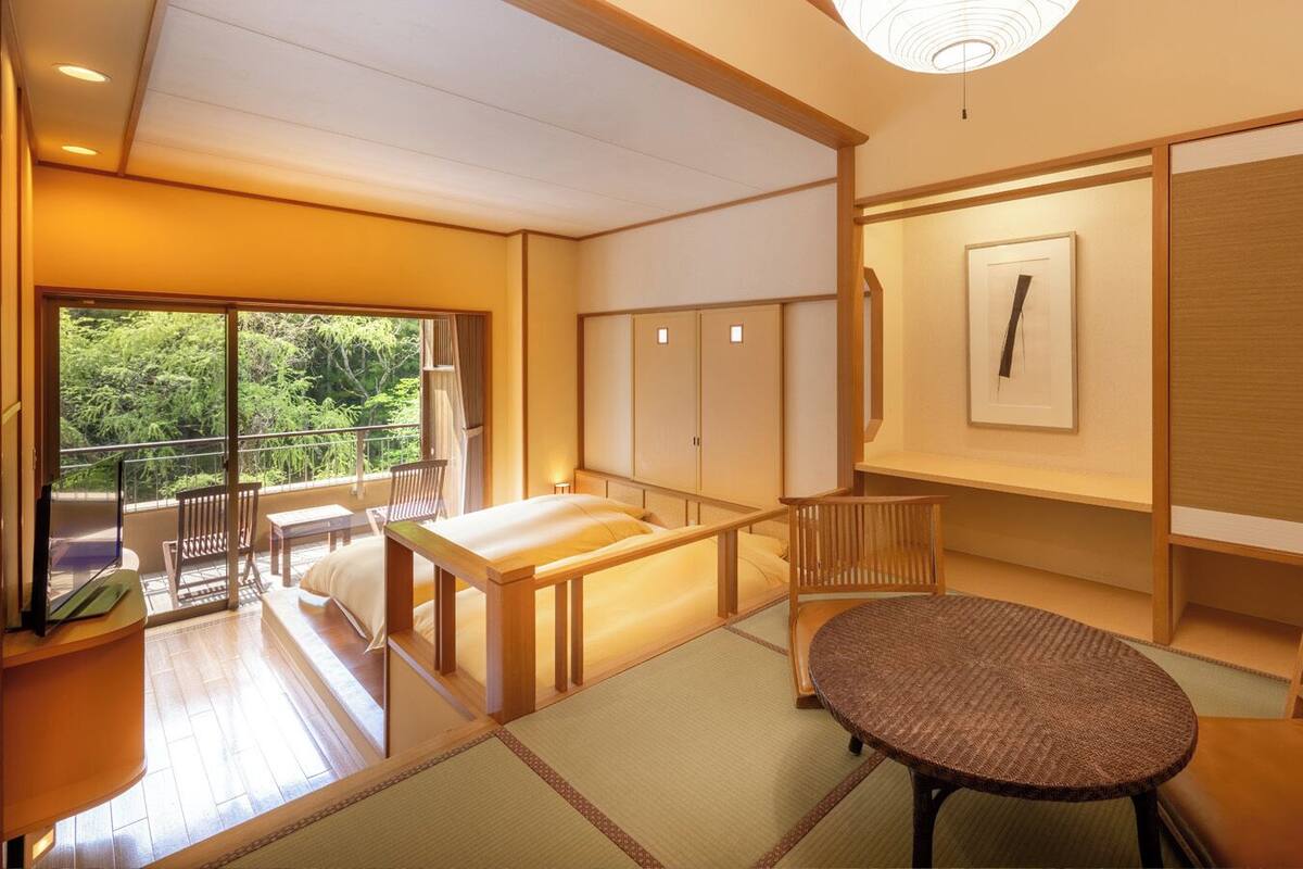 A traditional Japanese-style room with tatami flooring, a low table, a cushioned bench, and sliding doors.