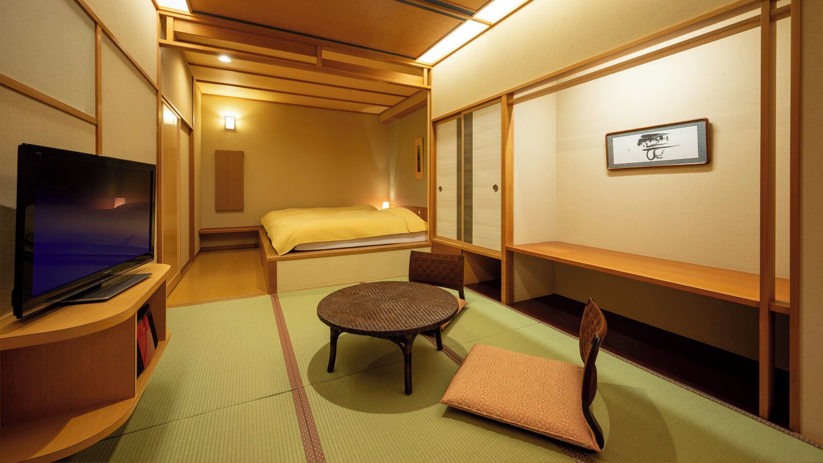 A traditional Japanese room with tatami flooring, a bed with a yellow blanket, a television on a wooden stand, a round table, and a chair.