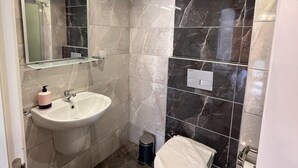 A modern bathroom with a white sink, a mirror, and a toilet. - Yelken Hotel Akyaka (Ula)