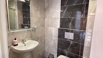 Quarto panorâmico, vista parcial para o mar | Banheiro | Chuveiro, produtos de toalete grátis, secador de cabelo, chinelos