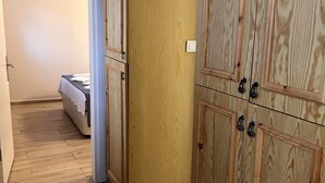 A room with wooden flooring, a bed with a white bedspread, and a large wooden wardrobe with multiple doors and handles. - Yelken Hotel Akyaka (Ula)