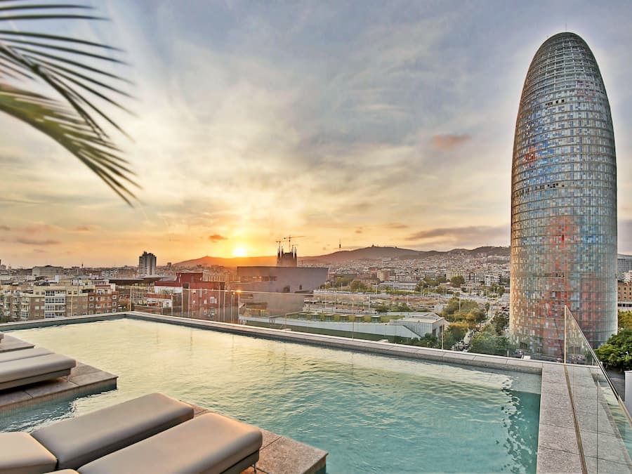 Een seizoensgebonden buitenzwembad, ligstoelen bij het zwembad