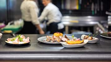 Een toonbank in een restaurant met diverse gerechten, waaronder een bord met vlees en groenten.