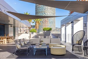 An outdoor seating area with tables and chairs, a sofa, and a decorative plant.