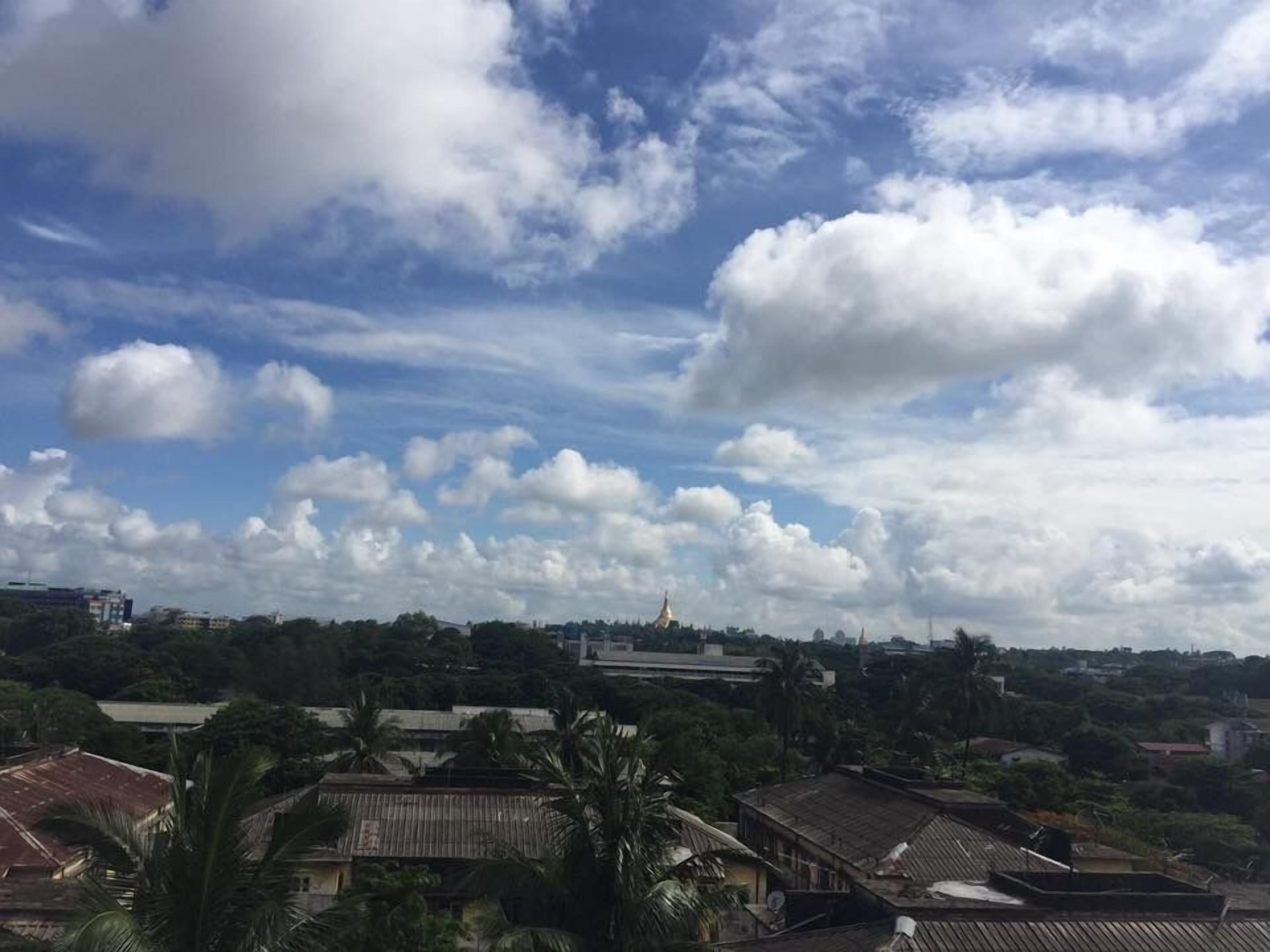 A view of a town with a prominent golden-domed building in the distance, surrounded by residential buildings and greenery.