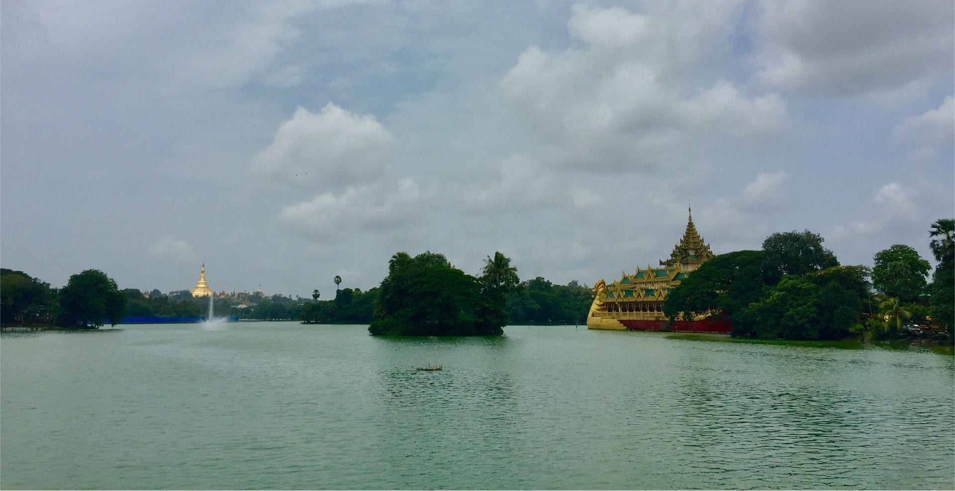A calm lake with a temple on the left and a pagoda on the right.