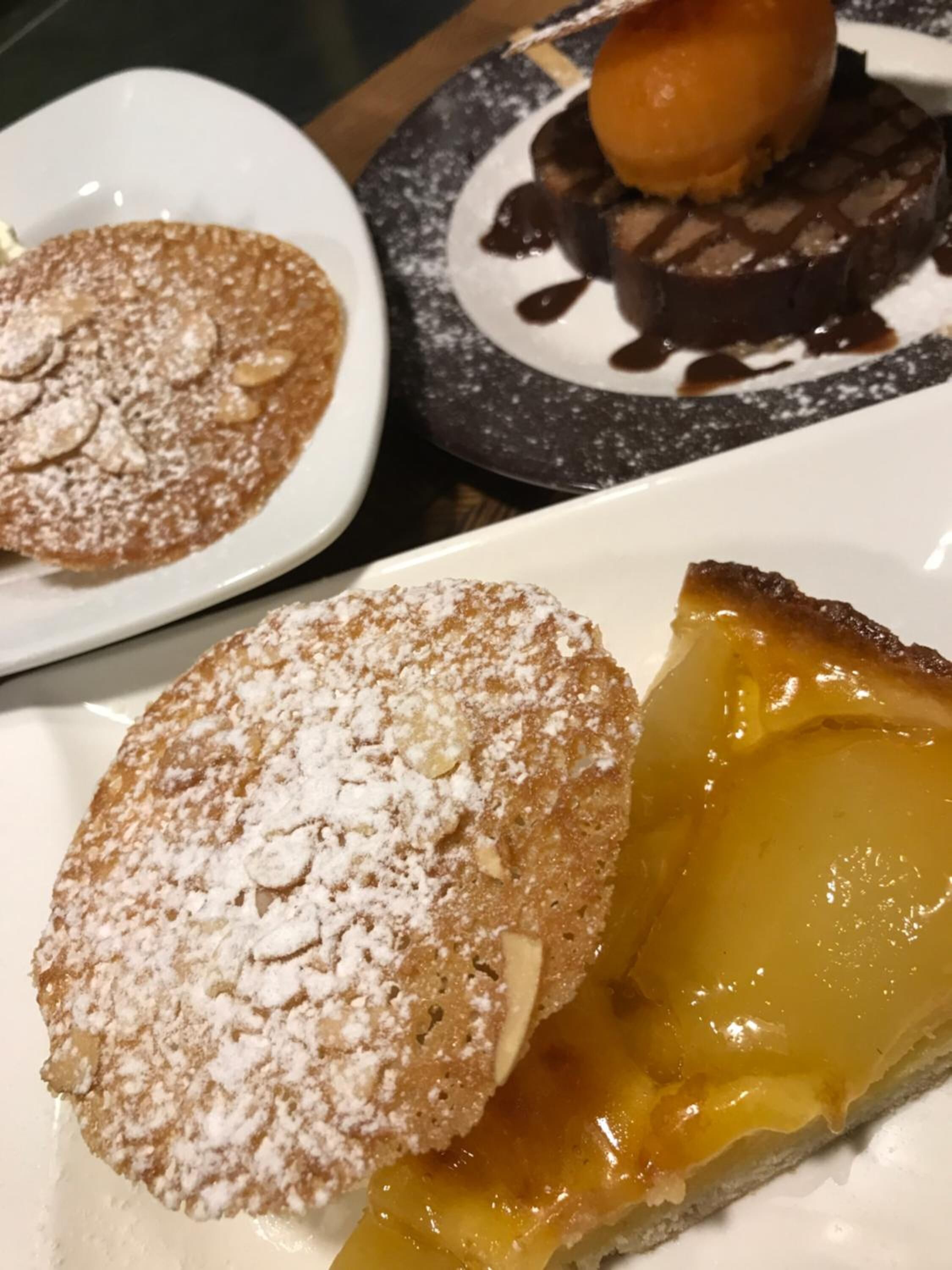 Un plato de postre con una porción de pastel y un pastelito espolvoreado.